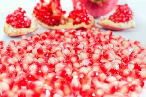 part of a pomegranate fruit with pomegranate seeds on white background photo