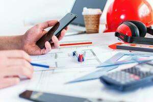 Close up man hand working of Architect sketching project on blueprint at site construction work. photo