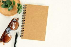 Office table with planner, sunglasses and pen. photo