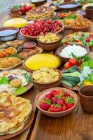 Homemade Romanian Food with grilled meat, polenta and vegetables Platter on camping. Romantic traditional moldavian food outside on the wood table. photo