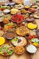 Homemade Romanian Food with grilled meat, polenta and vegetables Platter on camping. Romantic traditional moldavian food outside on the wood table. photo