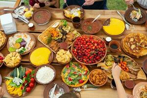 Homemade Romanian Food with grilled meat, polenta and vegetables Platter on camping. Romantic traditional moldavian food outside on the wood table. photo