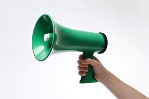 The hand holds a blue megaphone on a green background. Announcement concept. Shout It Out. photo