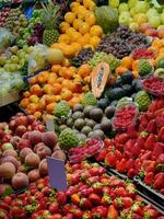 Beautiful display various kind of exotic tropical fresh fruits selling in local farmer market in Porto, Portugal, strawberries, grapes, pineapple, orange, papaya, apples, plums, peach, custard apple photo