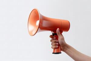 The hand holds a blue megaphone on a orange background. Announcement concept. Shout It Out. photo