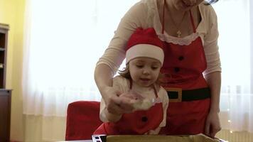 moeder met haar twee jaren oud dochter is verspreiden suiker poeder Aan Kerstmis biscuits video