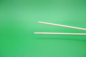 chopsticks isolated green background photo