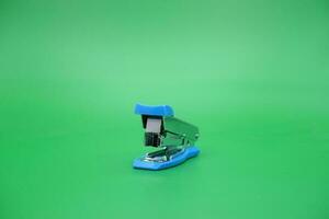 stapler isolated green background. Front view of the mini stapler. photo