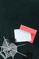 Creative halloween composition card, pink envelope, spider, spider web on black background with place for text, top view. photo