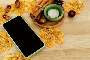 Autumn leaves and the smart phone on an old wooden background. Autumn on the concept. photo