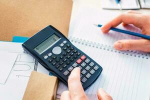 Bookkeeper using calculator counting finances, taxes, fees, accounting. photo