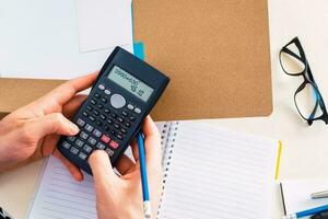 businessman working with financial report using calculator. Top view. photo