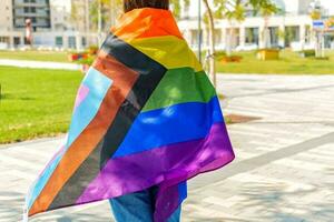 mujer con el nuevo Progreso orgullo bandera en su atrás. Progreso lgbtq arco iris bandera. foto