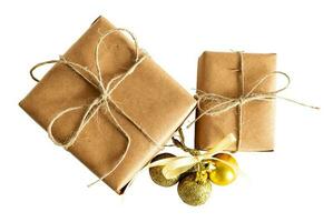 Christmas image with rustic brown gift boxes and golden baubles isolated on a blank background. photo