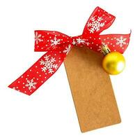 Kraft paper empty tag with red ribbon and bauble, Christmas ornaments on white or transparent background. Overhead view. photo