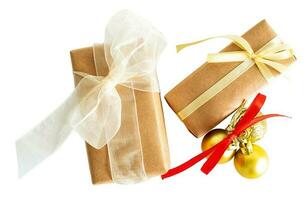 Two wrapped in rustic paper gift boxes with christmas baubles on white or transparent background. photo