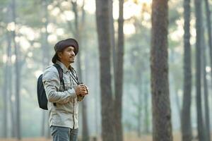 Bird watcher is looking through binoculars while exploring in the pine forest for surveying and discovering the rare biological diversity and ecologist on the field study concept photo