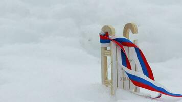 Wooden made mini sleighs and skating shoes in the snow. Free space for a text. Dynamic zoom video