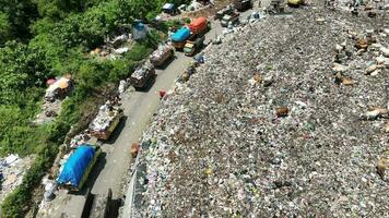 aereo Visualizza di un' città cumulo di rifiuti centro pieno di spazzatura. mandria di mucche mangiare spazzatura nel un' discarica. ecologia e Salute questioni. video