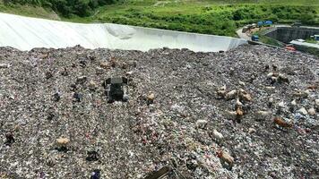 aereo Visualizza di un' città cumulo di rifiuti centro pieno di spazzatura. mandria di mucche mangiare spazzatura nel un' discarica. ecologia e Salute questioni. video