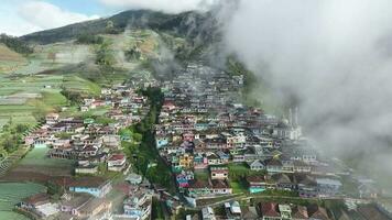 aérien vue de magnifique coloré villages dans Népal van Java sur monter sommation, magelang, central Java, Indonésie. caché village derrière des nuages et brouillard sur le pistes de monter sommation. video