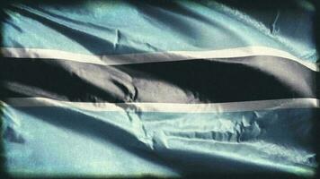 Retro aged Botswana flag waving on the wind. Old vintage banner swaying on the breeze. Seamless loop. video
