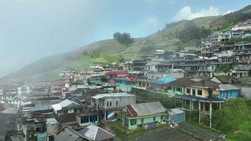 aéreo Visão do lindo colorida aldeias dentro Nepal furgão Java em montar somando, magolang, central Java, Indonésia. escondido Vila atrás nuvens e névoa em a declives do montar somando. video