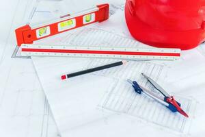 Construction plans with red helmet and drawing tools on blueprints. photo