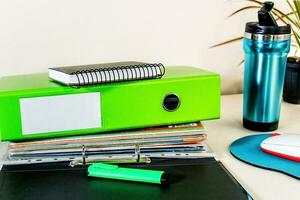 Coffee mug, notebook and stacked files on table. photo