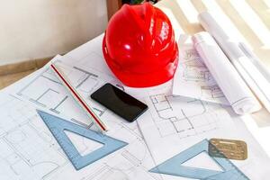 Top view workspace of architectural project with engineering tools, office supplies and smart phone on desk. photo