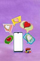 Mobile phone and dialogue bubbles with hearts. Dating app concept. photo