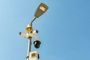 Cluster of security cameras on a lamppost, in an public Park on the sky background, with copy space. photo