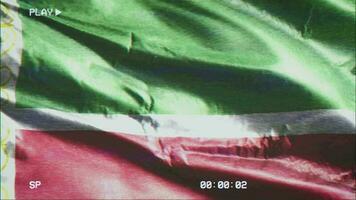 VHS video casette record Chechen Republic flag waving on the wind. Glitch noise with time counter recording banner swaying on the breeze. Seamless loop.