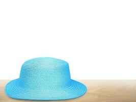 blue vintage straw hat on wooden table background isolated on white background photo