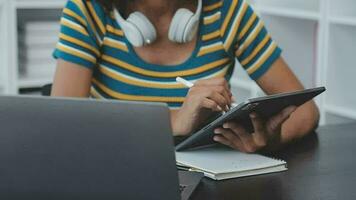 giovane adulto contento sorridente ispanico asiatico alunno indossare cuffie parlando su in linea Chiacchierare incontro utilizzando il computer portatile nel Università città universitaria o a virtuale ufficio. Università femmina alunno apprendimento a distanza. video