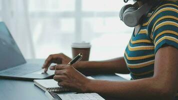 joven adulto feliz sonriente estudiante asiático hispano usando auriculares hablando en una reunión de chat en línea usando una computadora portátil en el campus universitario o en la oficina virtual. estudiante universitaria aprendiendo de forma remota. video