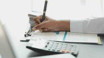 Asian Business woman using calculator and laptop for doing math finance on an office desk, tax, report, accounting, statistics, and analytical research concept video