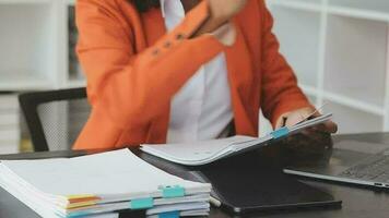 Asian Business woman using calculator and laptop for doing math finance on an office desk, tax, report, accounting, statistics, and analytical research concept video