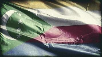 Retro aged Comoros flag waving on the wind. Old vintage Comorian banner swaying on the breeze. Seamless loop. video