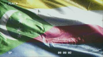 VHS video casette record Comoros flag waving on the wind. Glitch noise with time counter recording Comorian banner swaying on the breeze. Seamless loop.