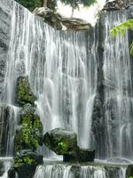 Slow motion natural cascade waterfall, tropical rainforest waterscape, long exposure shot, slope of rocks, beautiful nature for background wallpaper photo