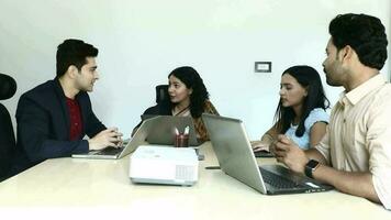 Video of Group of Young Team looking at laptop screen while discussing about project.