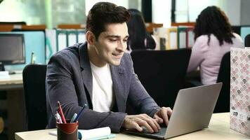 Video of Happy businessman relaxing with hands behind head after working on laptop in the office