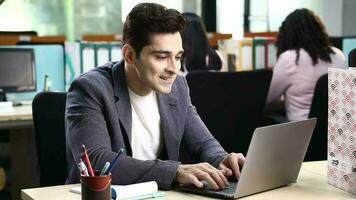 Video of Happy businessman relaxing with hands behind head after working on laptop in the office