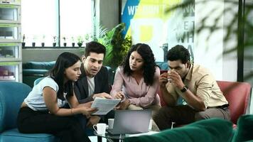 Stock video of small business team discussing new projects and documents at office while drinking tea