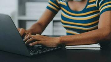 portret van Aziatische jonge vrouw die op laptop op kantoor werkt video