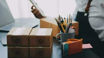 Emprendedora de pequeñas empresas o mujer asiática independiente que usa una computadora portátil con caja, joven mujer asiática de éxito con su mano levantada, caja de embalaje de marketing en línea y entrega, concepto de pyme. video