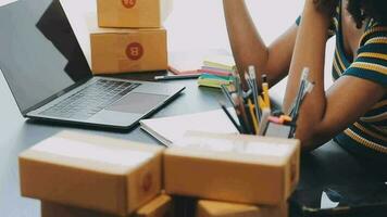 Emprendedora de pequeñas empresas o mujer asiática independiente que usa una computadora portátil con caja, joven mujer asiática de éxito con su mano levantada, caja de embalaje de marketing en línea y entrega, concepto de pyme. video