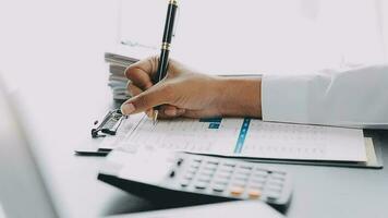 Asian Business woman using calculator and laptop for doing math finance on an office desk, tax, report, accounting, statistics, and analytical research concept video