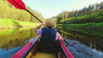 indietro posteriore Visualizza forte caucasico donna canottaggio kayak nel bellissimo Lituania campagna fiume - zemeina. azione telecamera pov di ragazza paddling su canoa. attivo vacanze divertimento all'aperto video